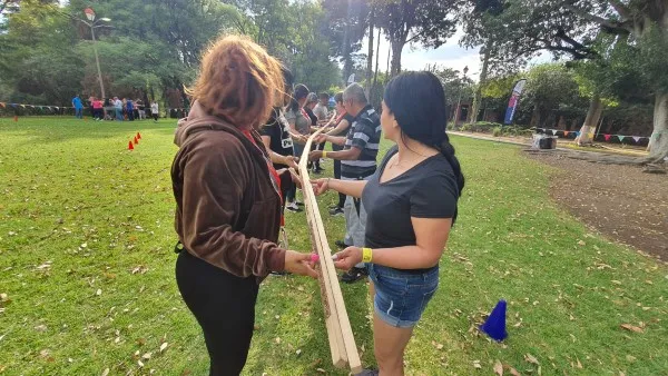 Colaboradores de una empresa participando en una dinámica de integración de equipos al aire libre, fortaleciendo la comunicación y el trabajo en equipo.