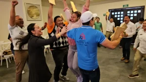 Colaboradores levantando los brazos en señal de éxito tras una dinámica de integración laboral.