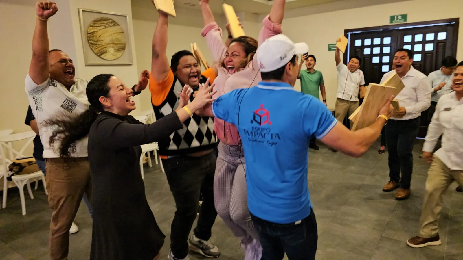 Festejo que refleja el sentido de logro al que se llega durante las dinámicas de integración laboral de Equipo Impacta. Dinámicas de integración laboral: Fotografía de personas saltando junto a un facilitador de Equipo Impacta.