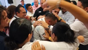 Un grupo abraza a un participante en el centro, creando un momento de profunda empatía y contención que puede surgir en prácticas de mindfulness en entornos grupales.