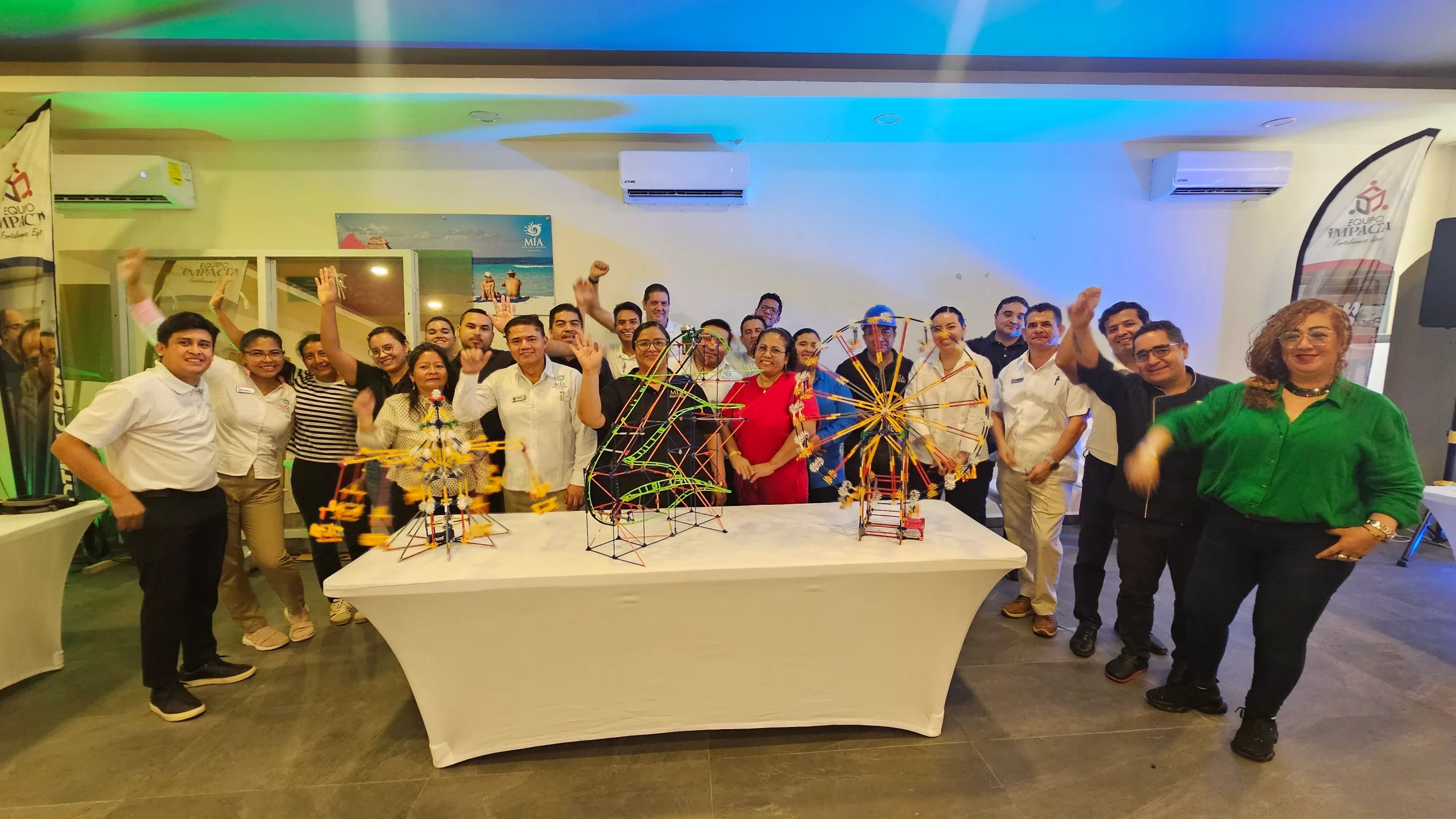 Después de completar la actividad de construcción, el equipo celebra los resultados obtenidos, ejemplo visual de los logros en sesiones de team building híbrido.