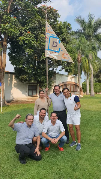 Foto de un equipo de trabajadores en el jardín con una bandera de victoria tras desarrollar sus soft skills