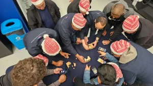 Fotografía desde arriba de personas con gorros rojos en actividad que beneficia la salud mental laboral