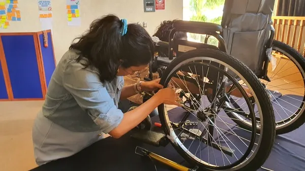 Colaboradora armando una silla de ruedas en actividad para mostrar que es responsabilidad social empresarial.