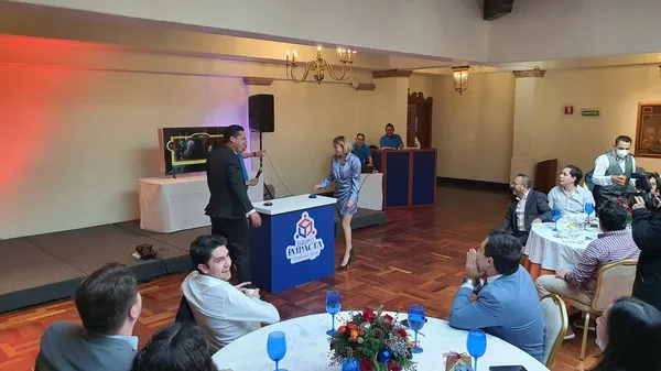 Dos personas paradas en un módulo participando en dinámica 100 mexicanos dijeron juego de preguntas y respuestas.