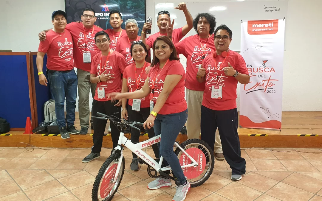 Fotografía de colaboradores de una empresa con la bici que armaron durante las actividades de integración.