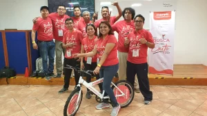 Fotografía de colaboradores de una empresa con la bici que armaron durante las actividades de integración.