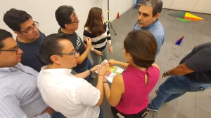 Fotografía desde arriba de colaboradores de una empresa realizando una dinámica para promover la integración de equipos.