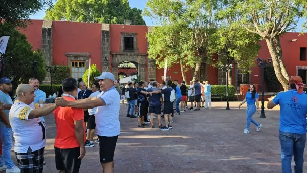 Fotografía de personas de pie reunidas en equipos durante actividad para prevenir la victimización en equipos de trabajo.
