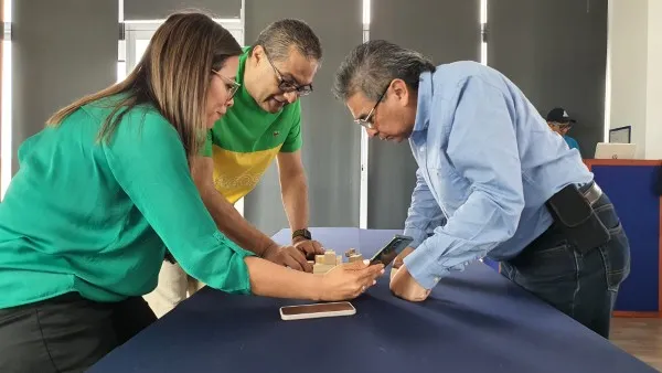Fotografía de tres personas realizando una dinámica para aprender cómo resolver conflictos entre compañeros.