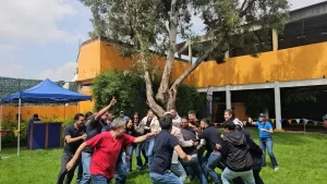 Fotografía de un grupo de personas al aire libre realizando actividad para el manejo de las emociones en el trabajo.