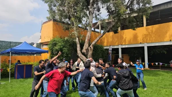 Fotografía de un grupo de personas al aire libre realizando actividad para el manejo de las emociones en el trabajo.