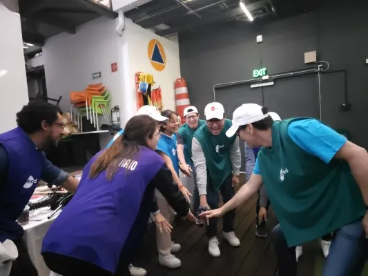 Fotografía de personas con chalecos verdes realizando dinámica para corregir la victimización en equipos de trabajo.