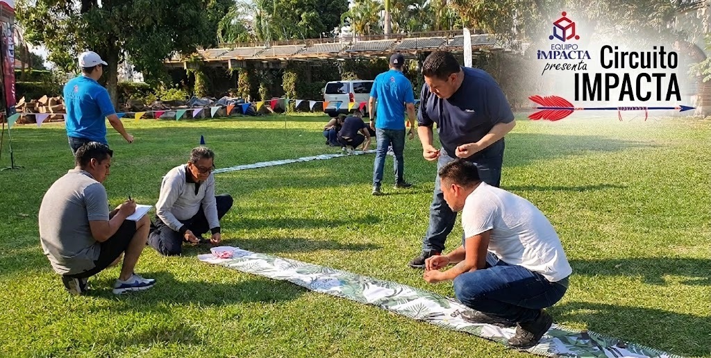 Fotografía de 4 personas al aire libre realizando Circuito Impacta caminando sobre una línea trazada.