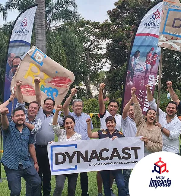 Fotografía de un grupo de personas sosteniendo un cartel de Dynacast después de realizar el rally de integración.