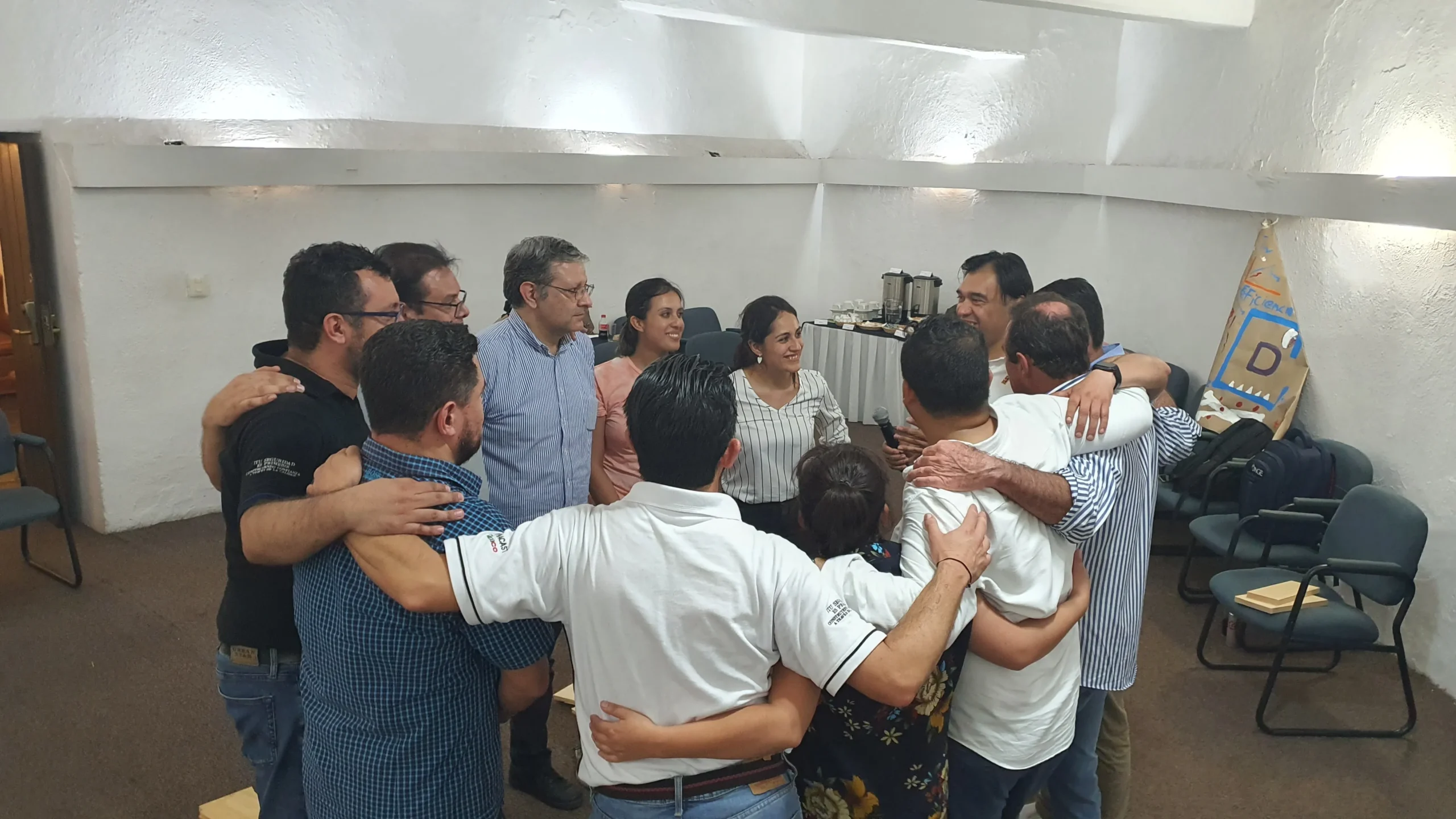 Proceso de integración laboral: fotografía desde arriba de un grupo de colaboradores abrazados formando un círculo.