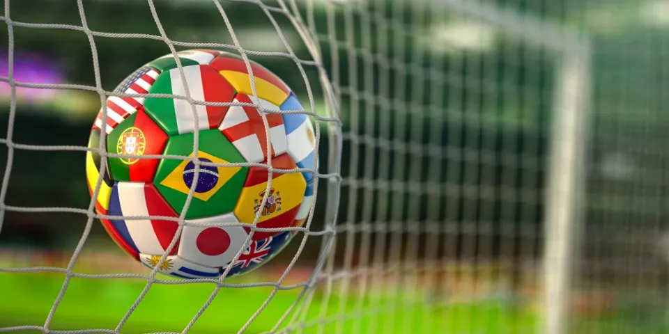 Dinámica de Mundialito para reforzar la integración laboral y mejorar la productividad con actividades deportivas. Mundialito: Fotografía de un balón de fútbol estampado con banderas de diferentes países en una portería.