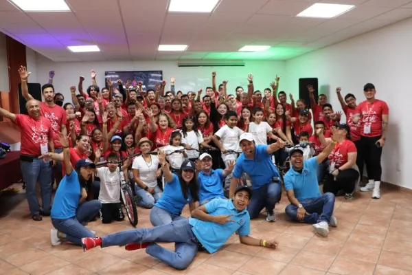 Team building Querétaro para impulsar la integración laboral entre las distintas áreas de una empresa. Team building Querétaro: Fotografía de un grupo de personas con playeras color azul y otras con playeras color rojo.