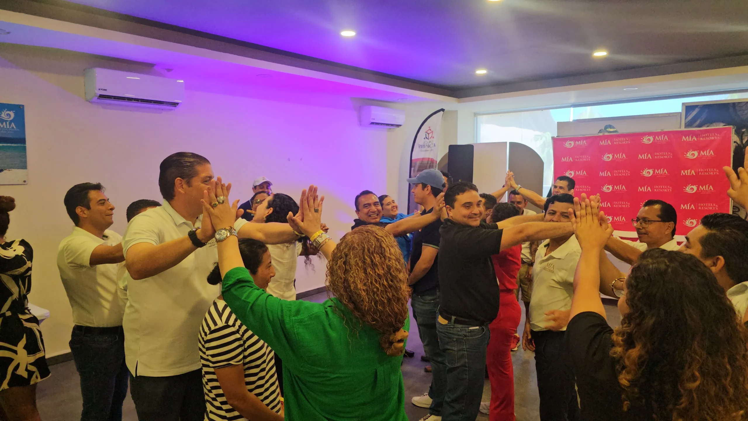 Cómo mejorar el clima laboral en una empresa: Fotografía de personas en parejas juntando sus manos y otra persona en medio.